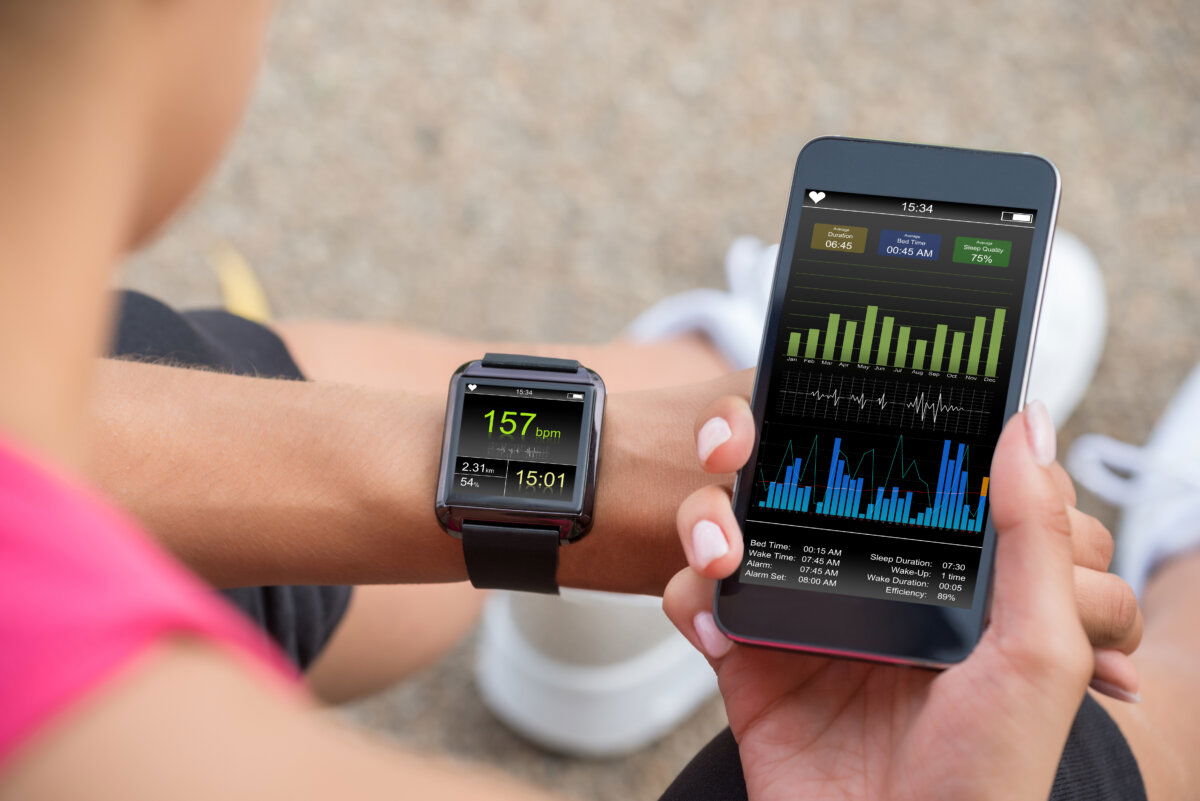 Close-up of a person using a wearable fitness tracker and smartphone app to monitor real-time heart rate, distance, and sleep data – showcasing the potential of 5G RedCap technology for reliable, low-latency, and energy-efficient connectivity in health and fitness wearables within the IoT ecosystem.